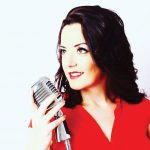 Singer Tianna Hall in a red dress at a vintage style microphone.
