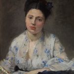 Portrait of a woman with dark hair on top of her head and white blouse with light blue flowers.