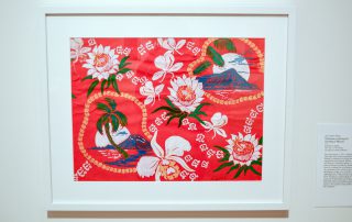 Framed print of blue volcanoes, white flowers, and green palm trees on a red background