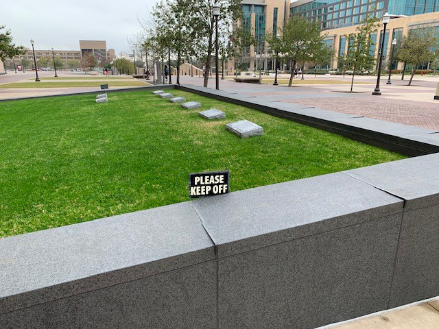 Photograph of Reveille Memorial gravesite looking toward Texas A&M Hotel and Conference Center