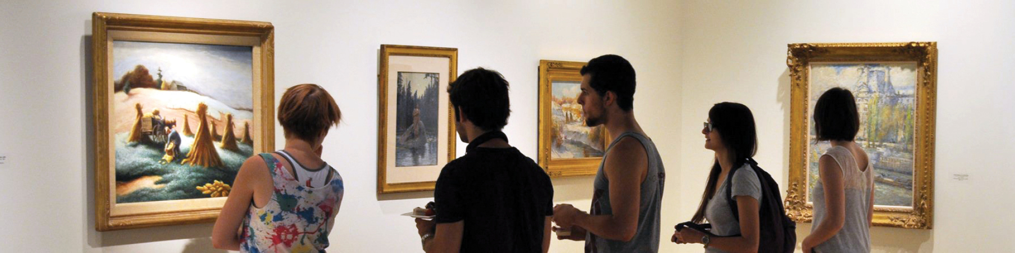 Students look at paintings hanging on the wall inside the Forsyth Galleries.
