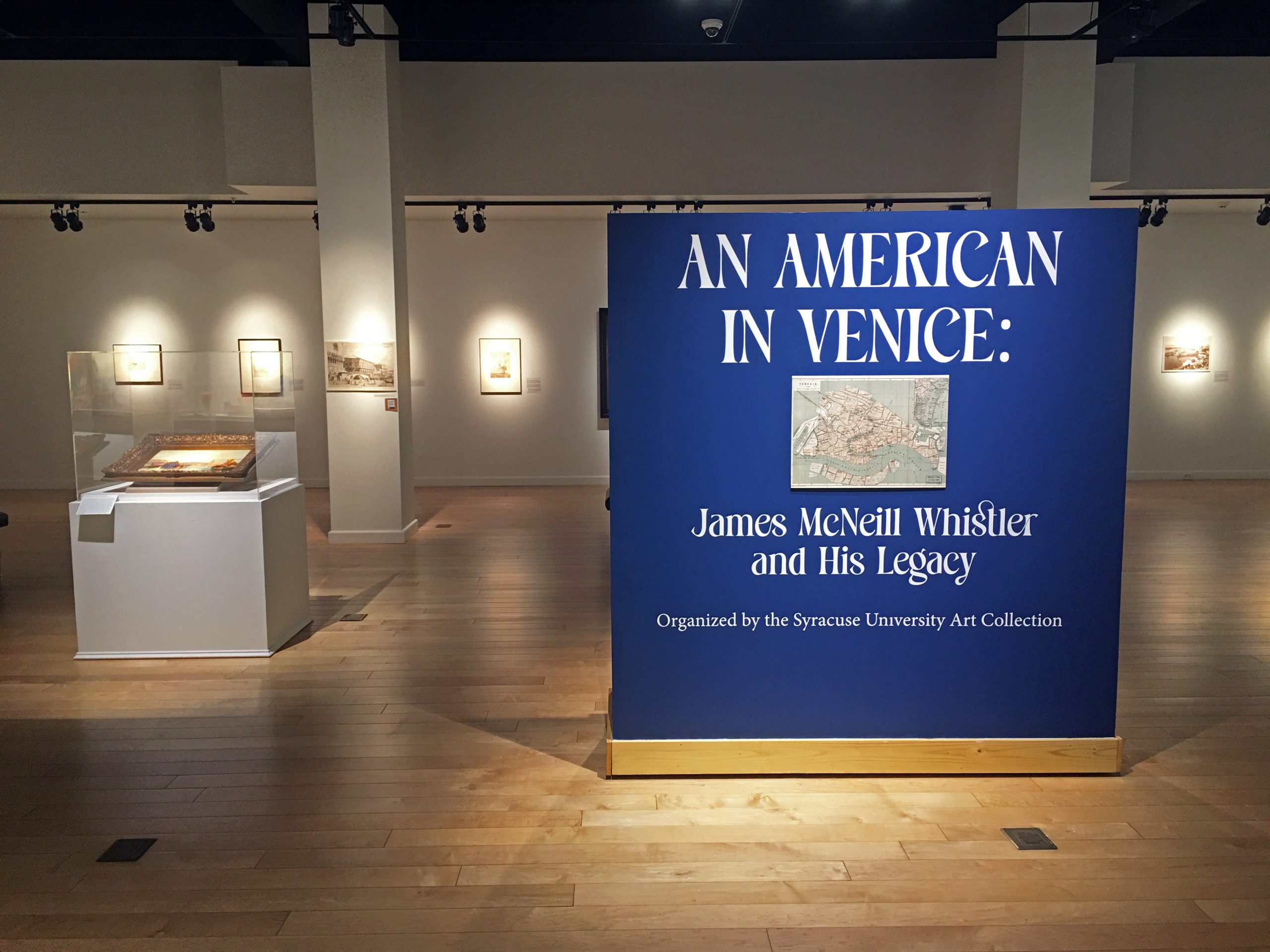 Interior view of Forsyth Galleries. Title wall is bright blue and features a map of Venice.