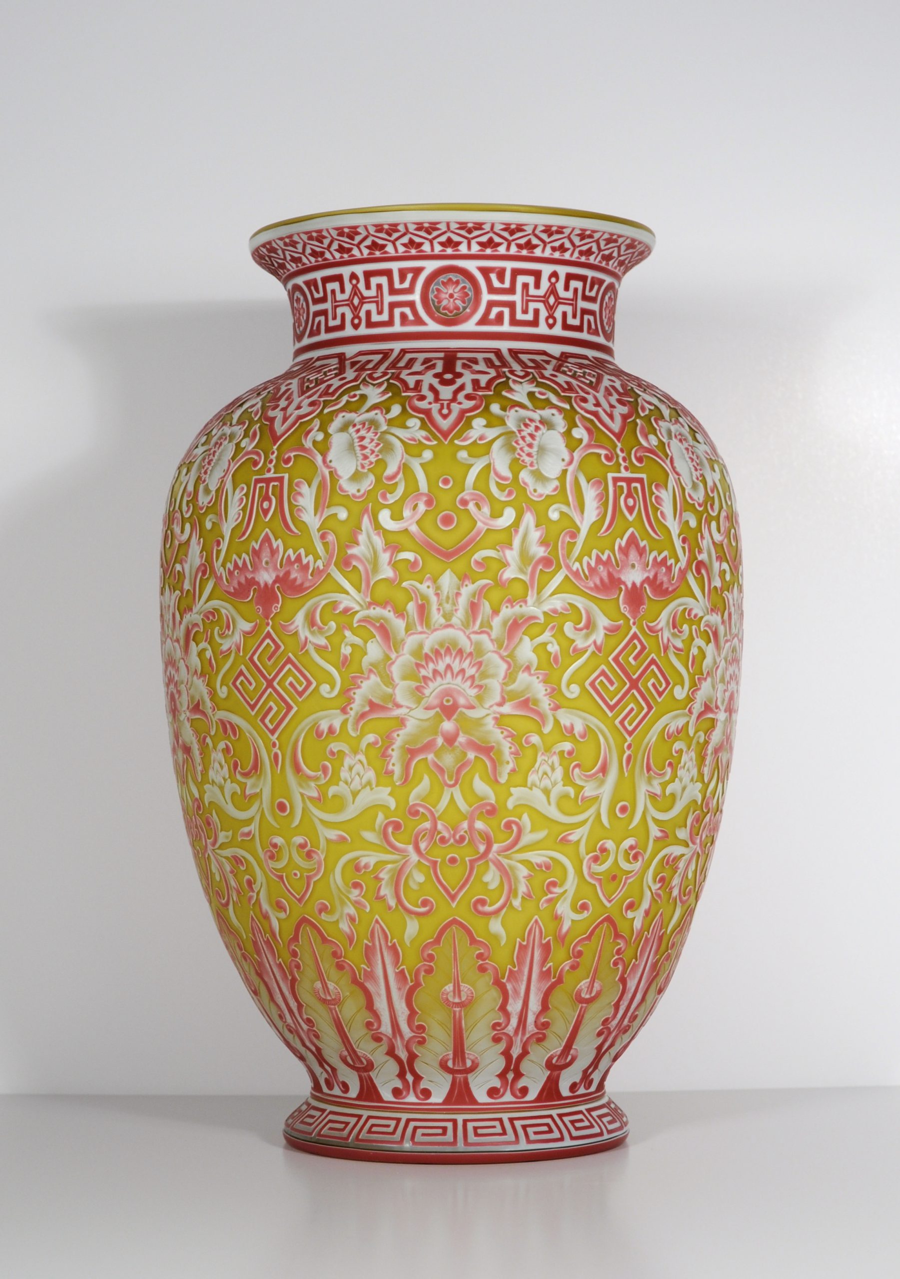 Footed  Urn-shaped Vase.  English Cameo Glass.  Red on white on citron on white on ivory. A rare 5 layer vase with Asian inspired floral tapestry motif. A repeating design made of stylized flowers, bats and Chinese symbols.