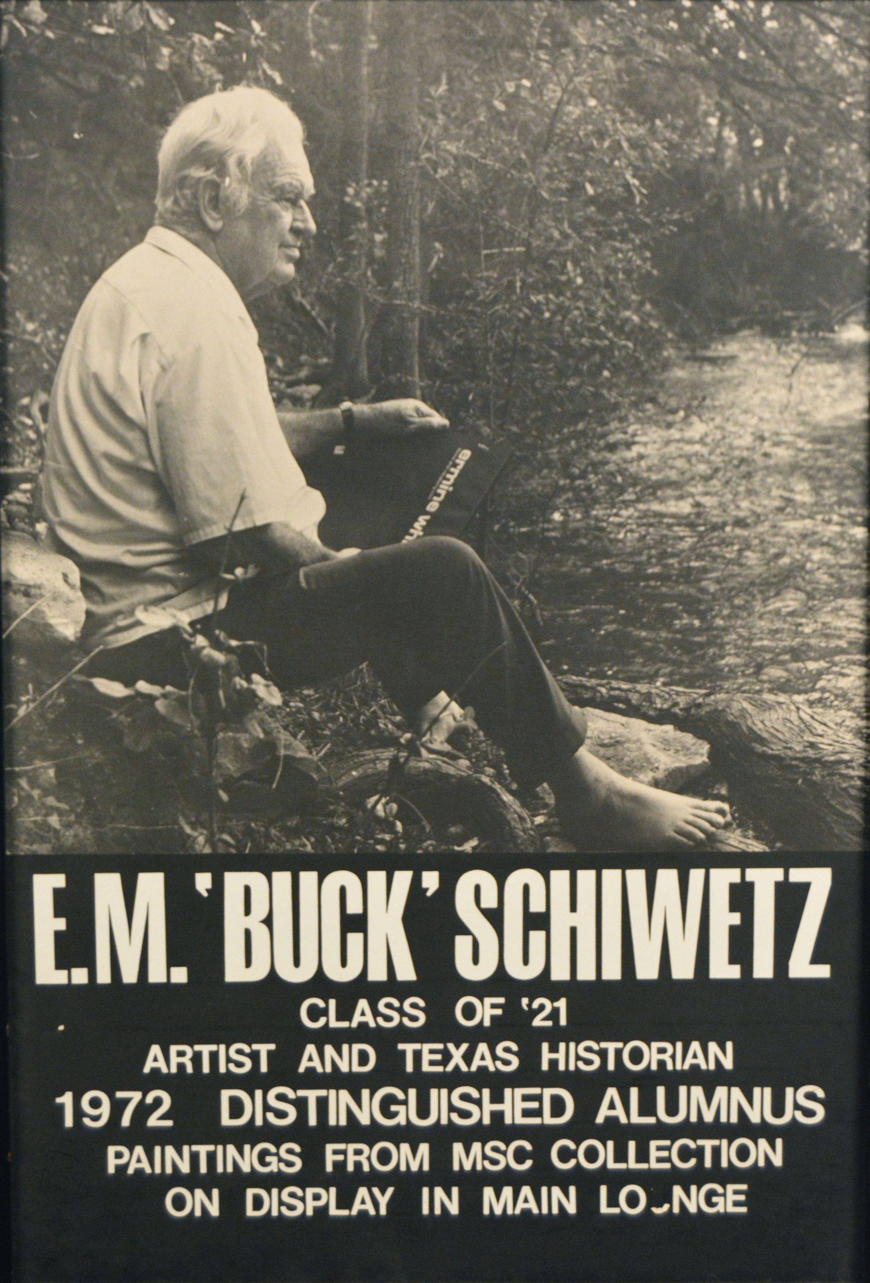 Advertising poster for a 1976 gallery exhibition. Black and white photo of Buck Schiwetz seated bare foot next to a riverbank facing right. Text below reads E.M. ‘Buck’ Schiwetz, Class of ’21, 1972 Distinguished Alumnus, Paintings from MSC Collection on Display in Main Lounge.