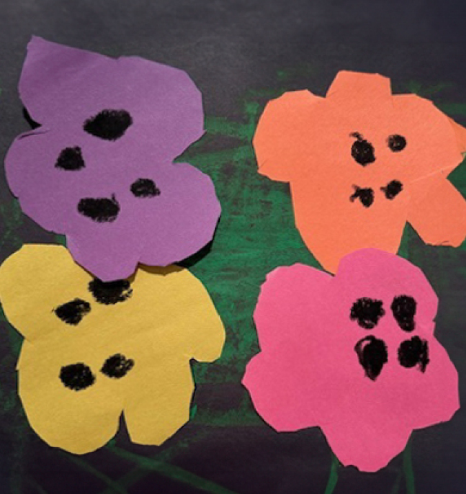 Child's artwork in the style of Andy Warhol on black construction paper with a green paint streak background and colored construction paper flowers glued in the center (purple, orange, yellow, and pink). 