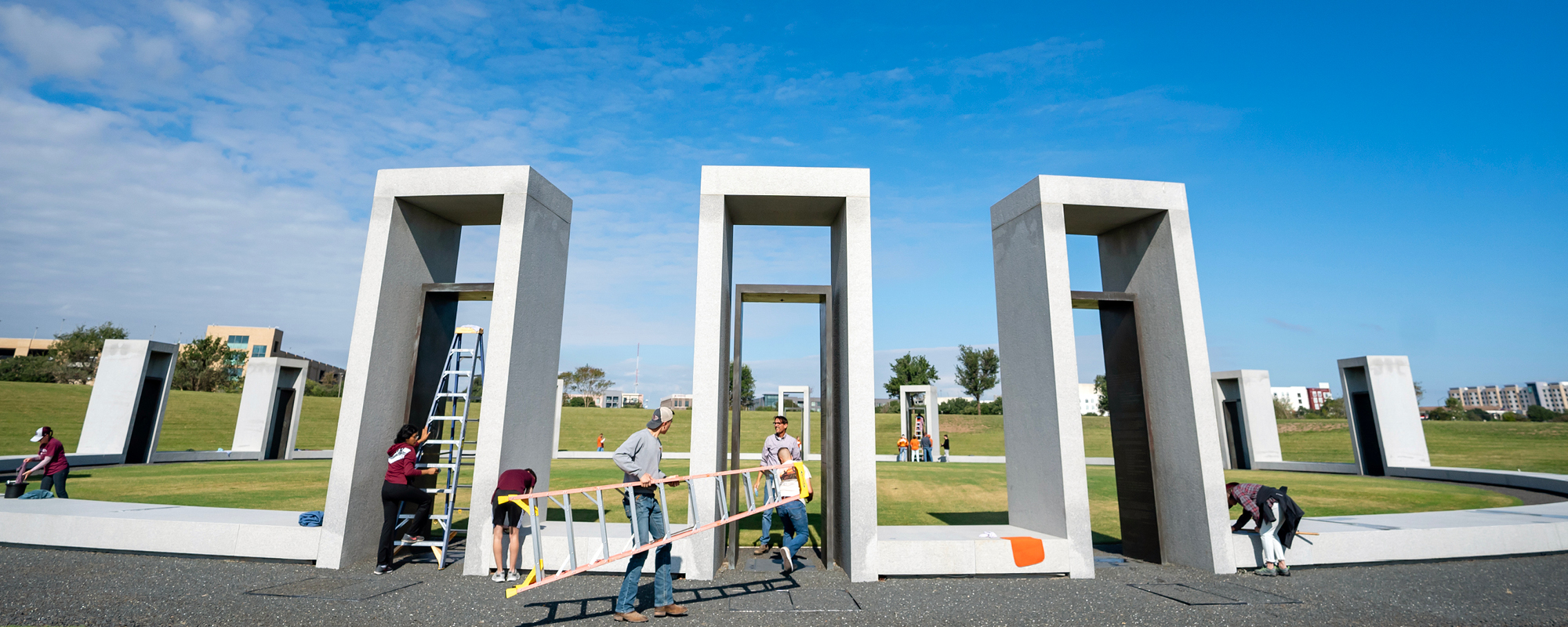 Students and staff clean the Bonfire Memorial with cleaning supplies and ladders. 