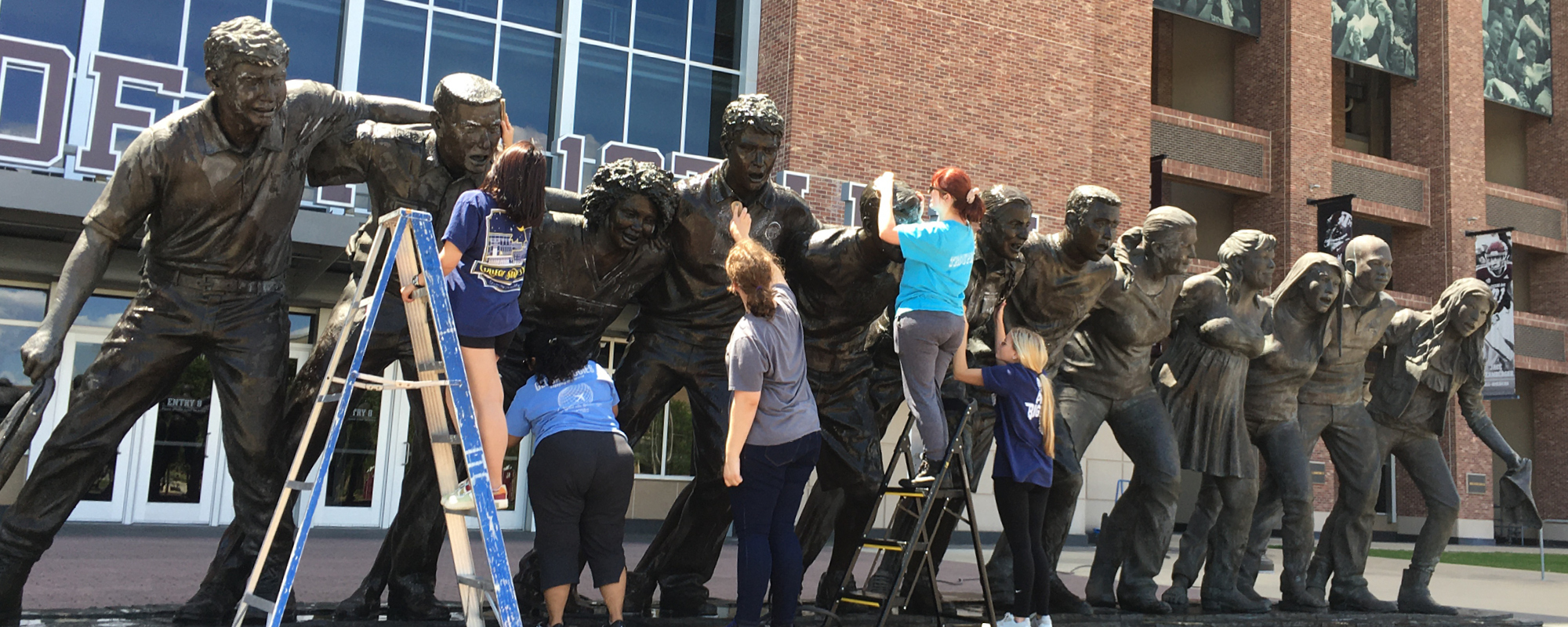 Staff and students wash the Aggie War Hymn statue.