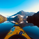 Kayak on water overlooking mountains on the horizon.