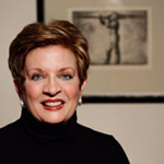 Headshot of Sheryl Fiegel standing in front of an art print in the background.